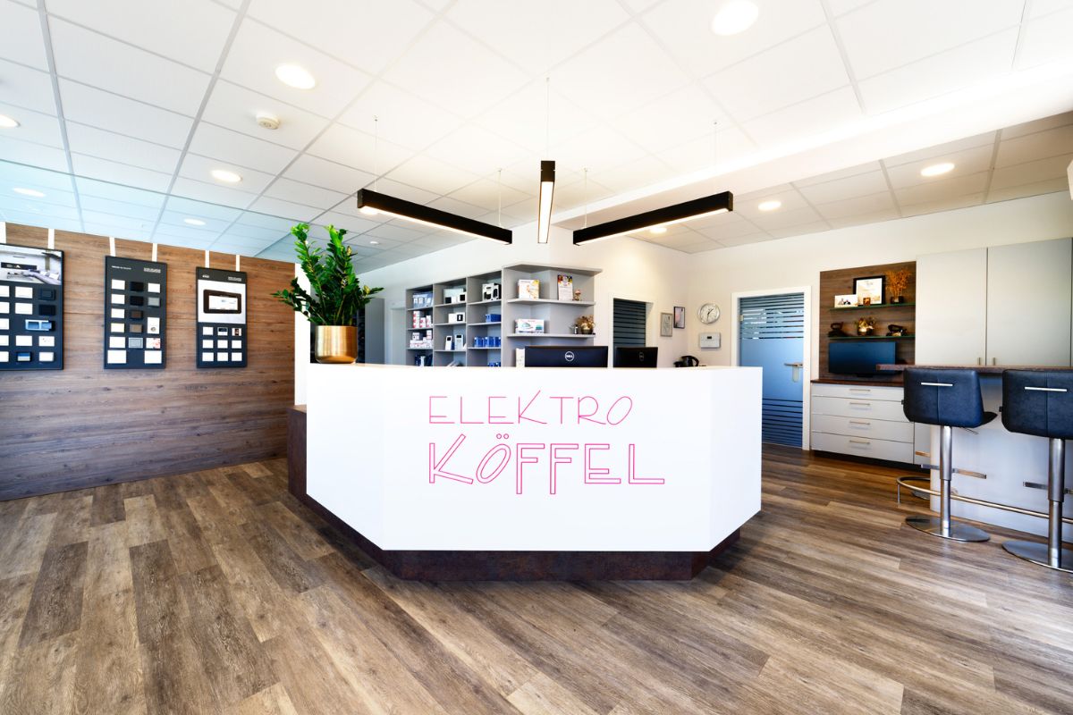 Empfangsbereich der Alfred Köffel GmbH mit Firmenlogo und Mustertafeln – moderner Schauraum in Zeltweg