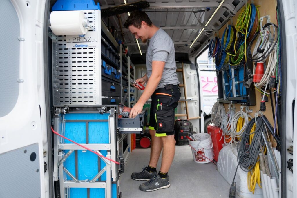 Servicefahrzeug der Alfred Köffel GmbH mit Ausstattung für Elektroinstallationen – Techniker beim Beladen vor Einsatz