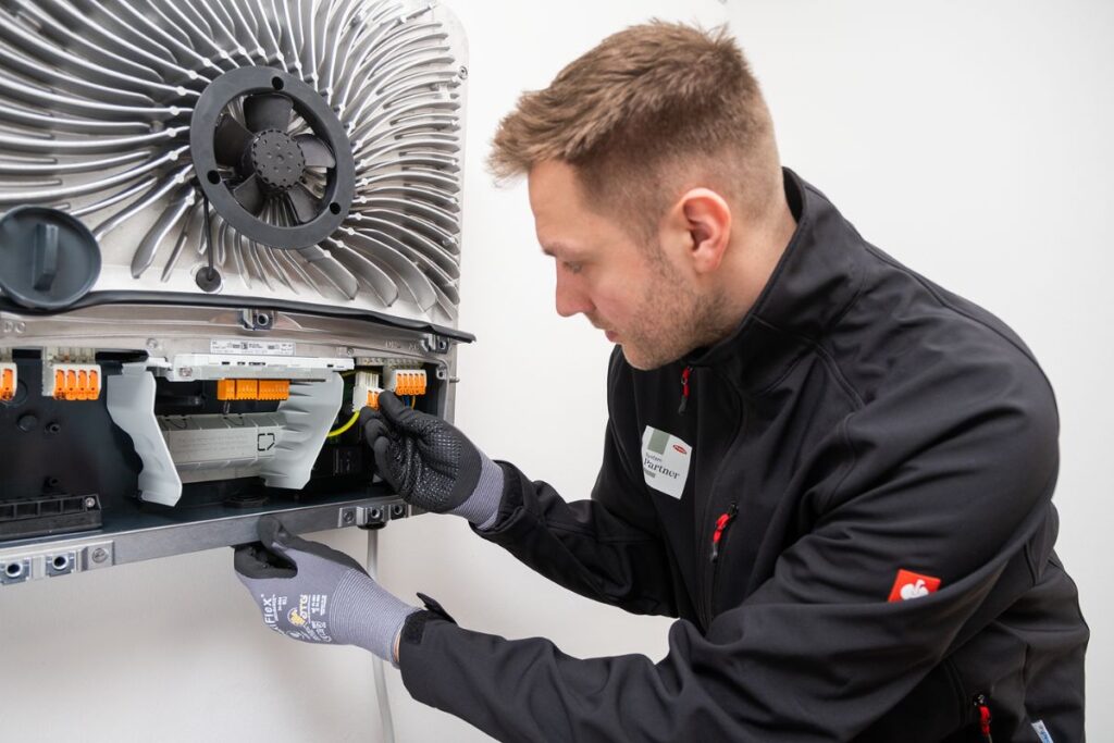 Techniker bei der Installation einer Photovoltaikanlage mit Fronius-Komponenten